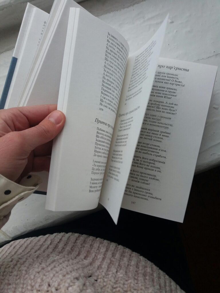 A person flipping through a book on a white surface, close-up view.